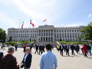 Clădirea Parlamentului, steaguri, oameni, cer senin.