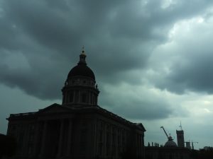 Clădire guvernamentală cu fum în fundal.